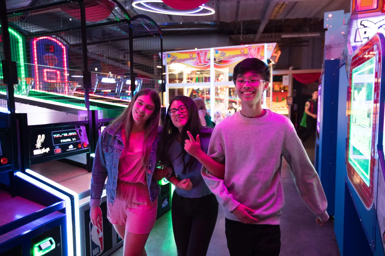Students walking linked arms through arcade