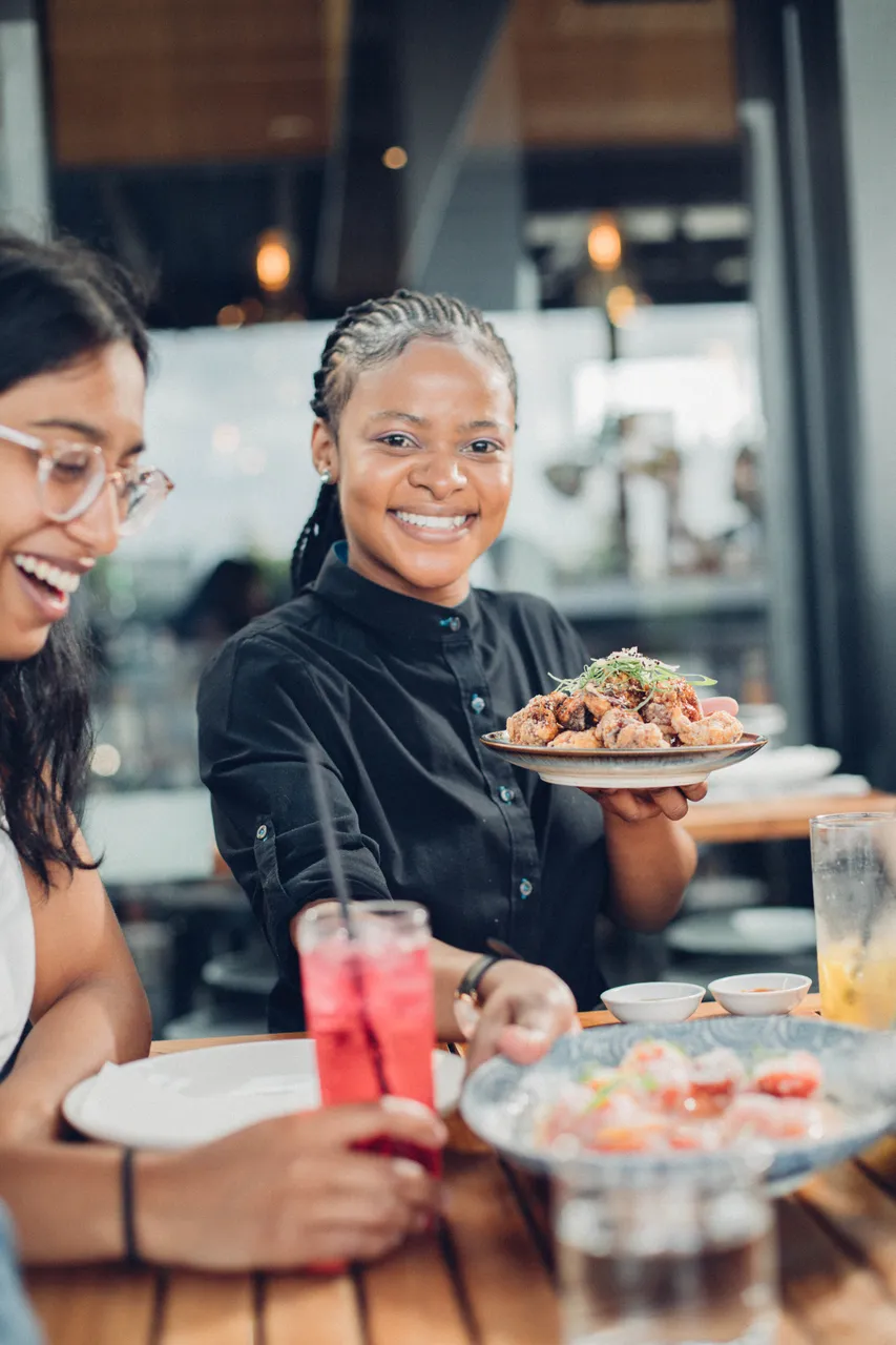Smiley waitress holding up food