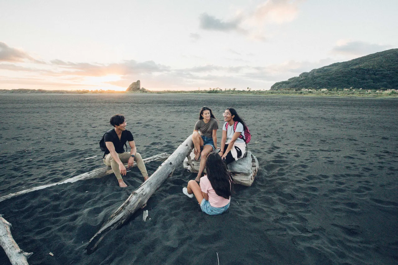 People sitting on the beach interacting