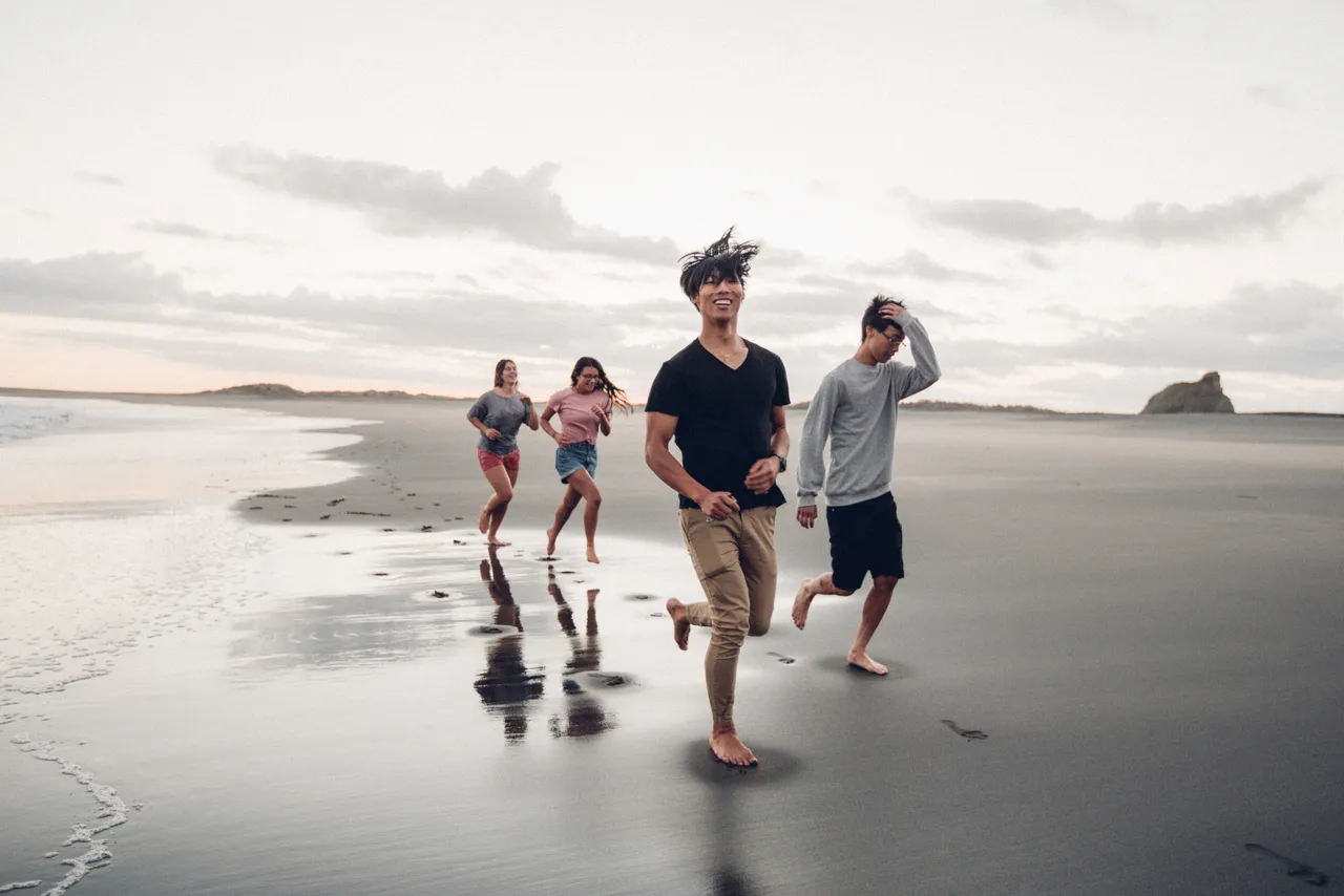 Group of people running along the beach