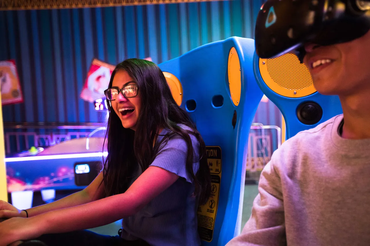 Girl and boy having fun at the arcade
