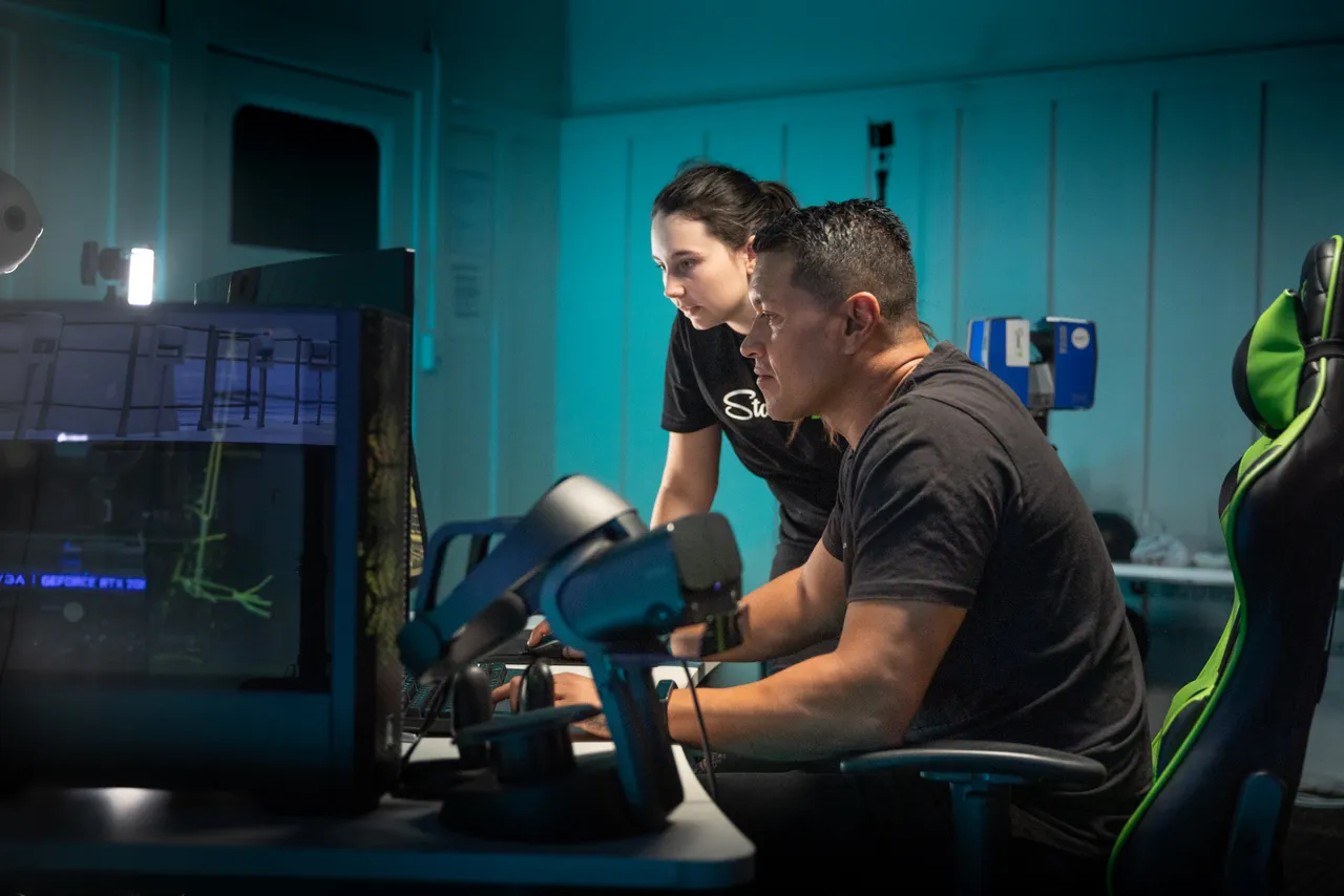 Man and woman working on computers in digital studio