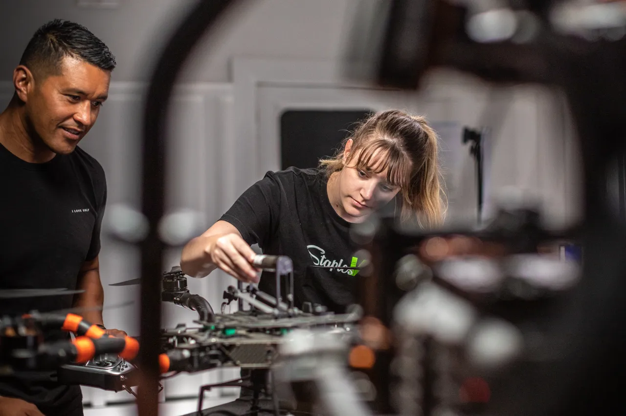 Woman and man working on drone