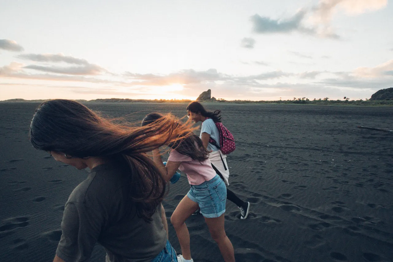 Girls running on beach side by side