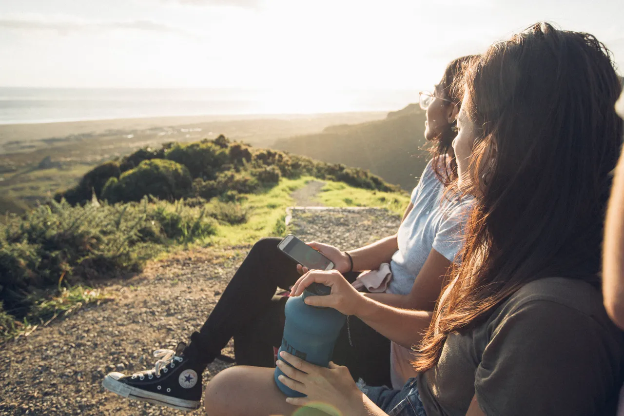 Girls sitting looking at the ocean