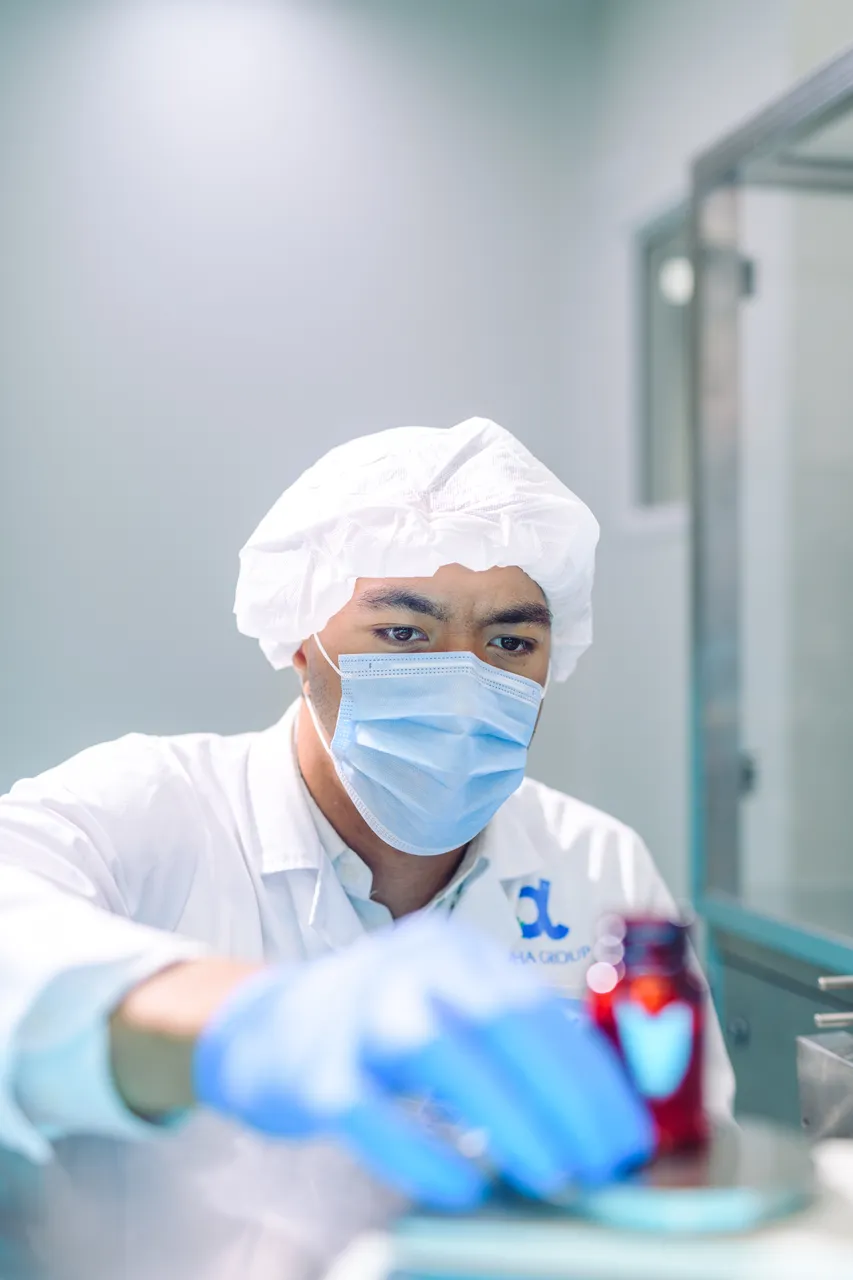 Man inspecting bottle at production facility