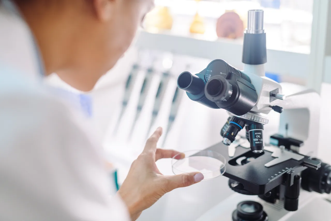 Woman with microscope in research lab