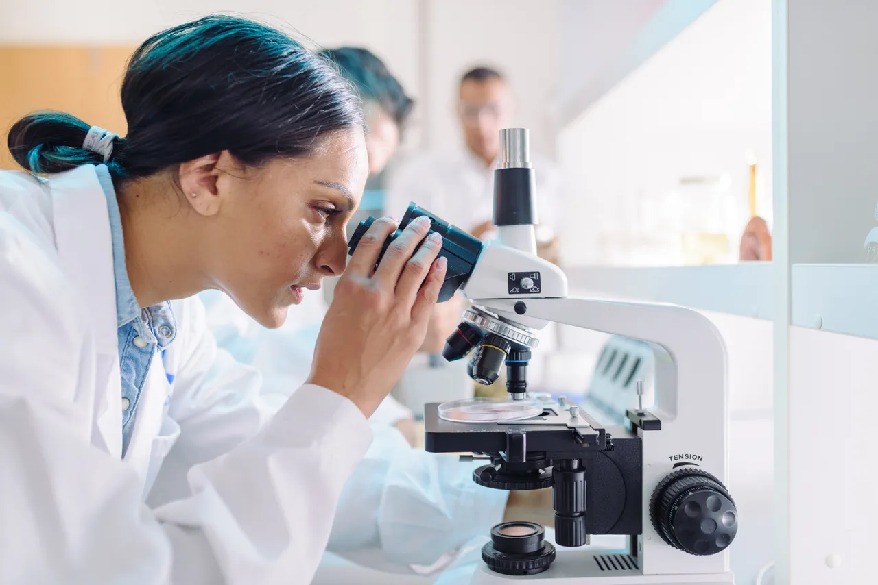 Woman looking into microscope