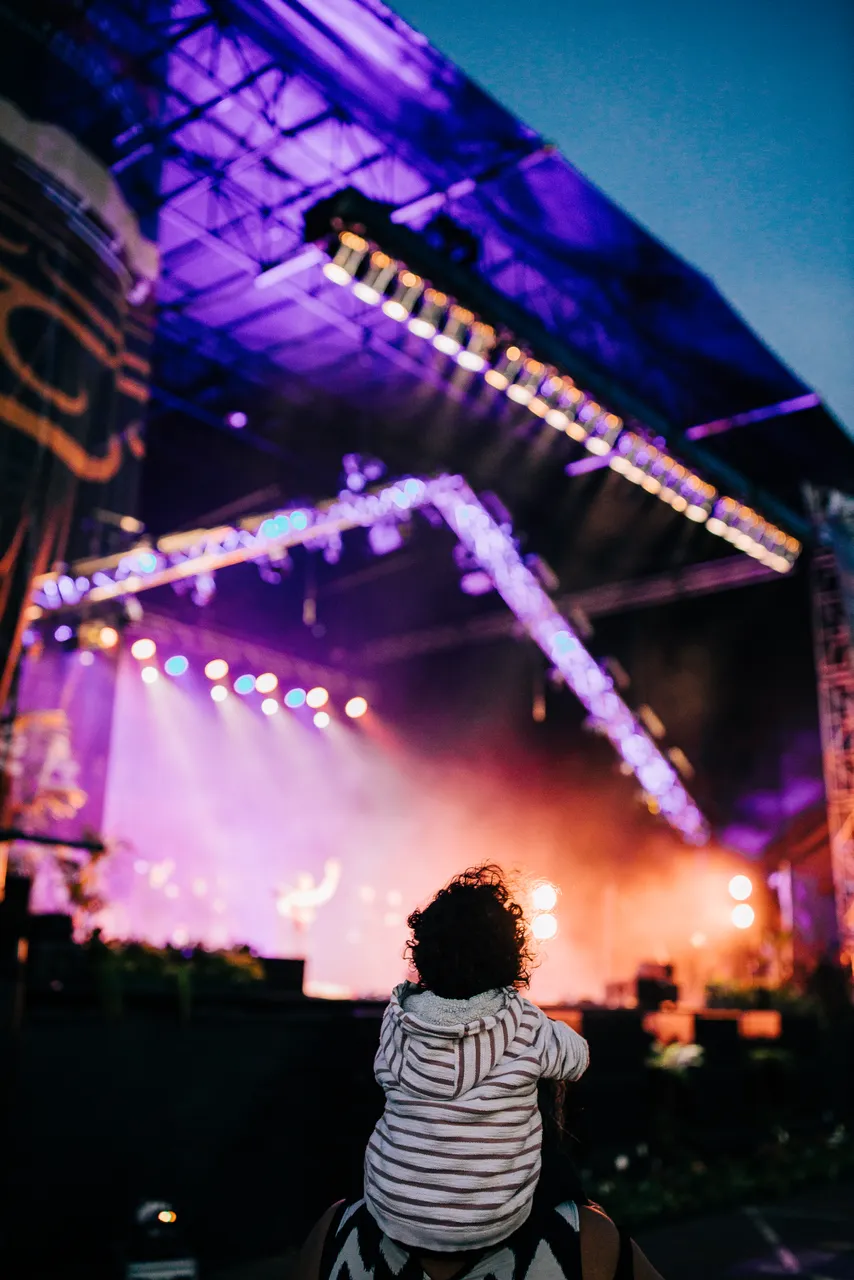 Child on shoulders watching concert in Auckland