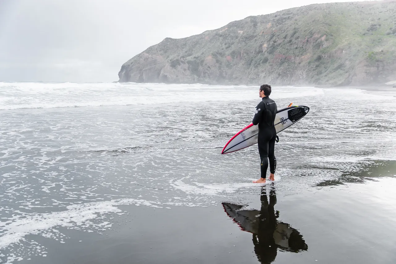 A surfer at Piha Beach