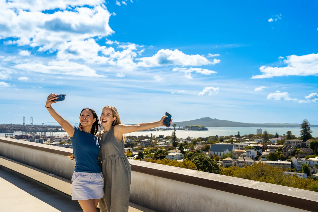 Female friends taking selfie on Auckland Museum's rooftop