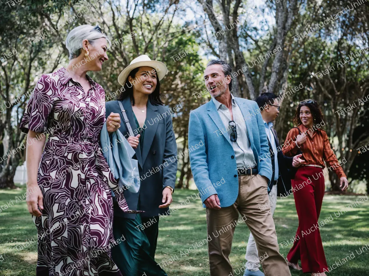 Group of business professionals walk the lawns of Waiheke vineyard 4