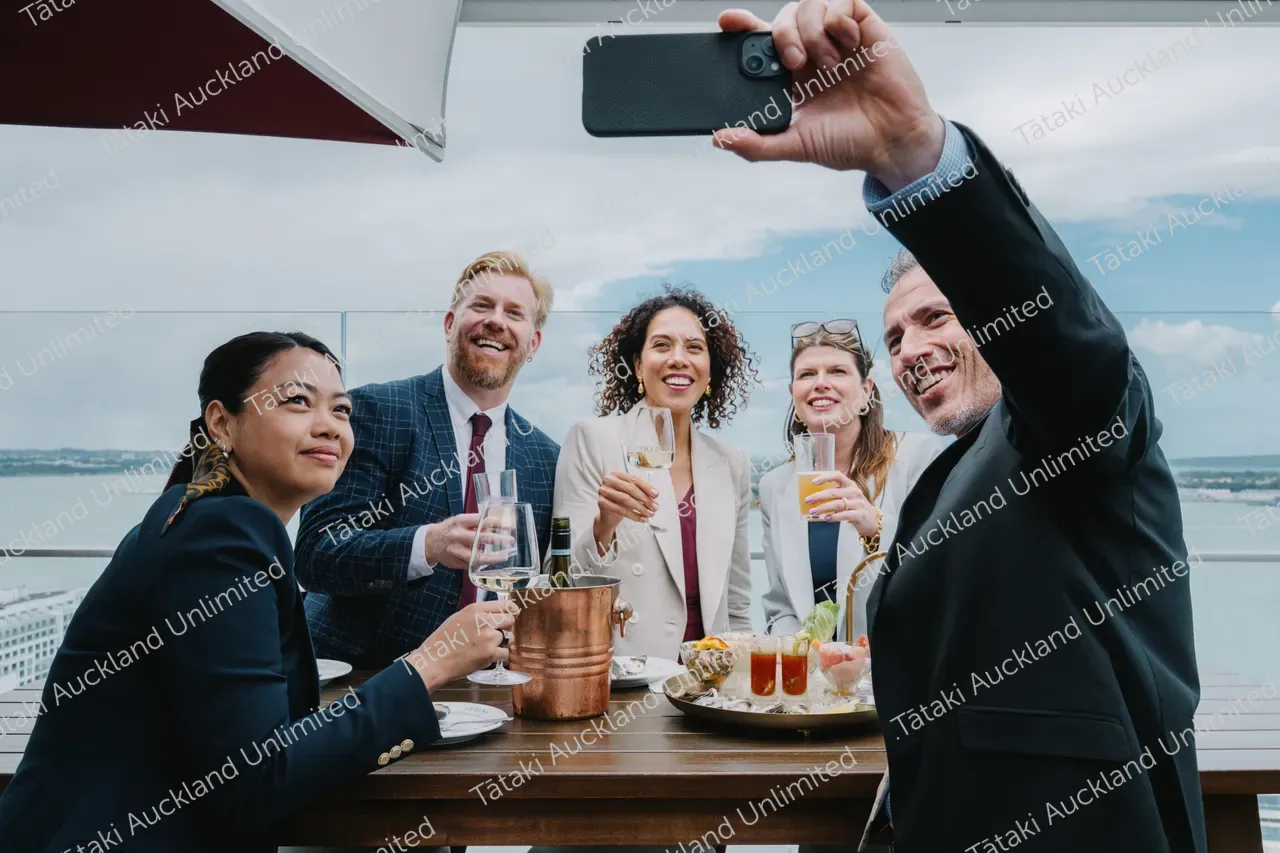 Five business professionals share a rooftop terrace meal 3