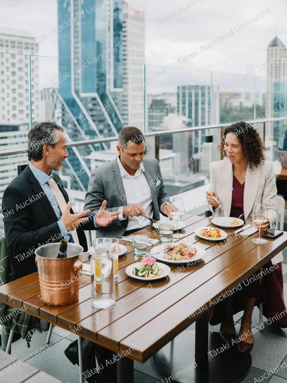 Business professionals dine on a rooftop terrace with city skyline views 11