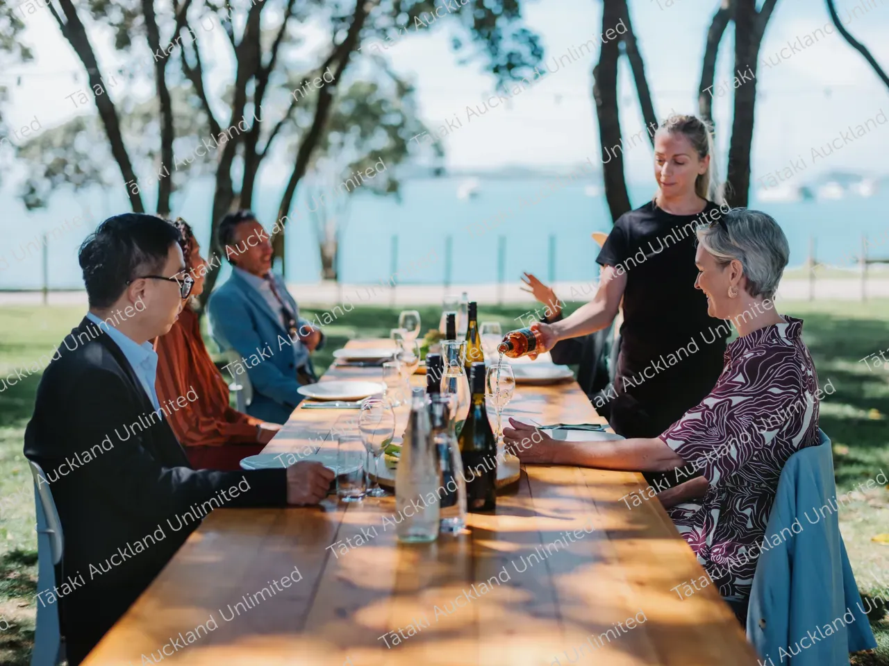 Business professionals dine outdoors at Waiheke vineyard