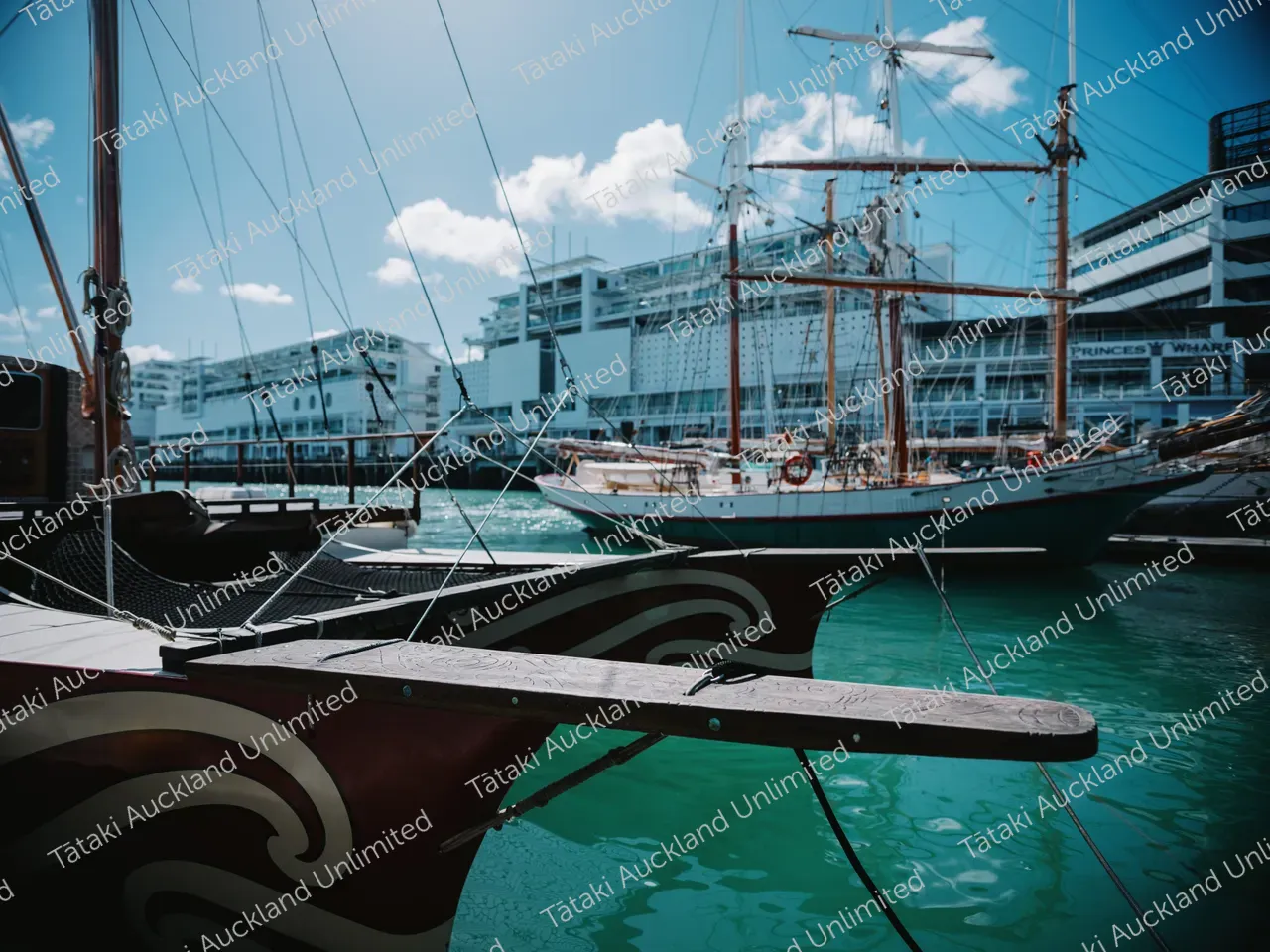 Tall-masted sailing ships are moored beside modern buildings at Auckland’s Princes Wharf.