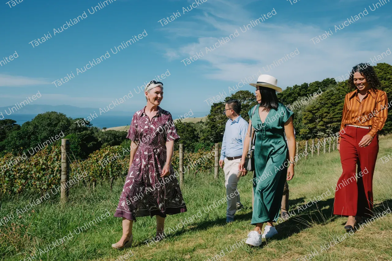 Group of business professionals walking through vines at Waiheke vineyard 2