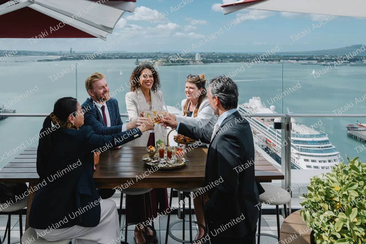 Five business professionals share a rooftop terrace meal 6