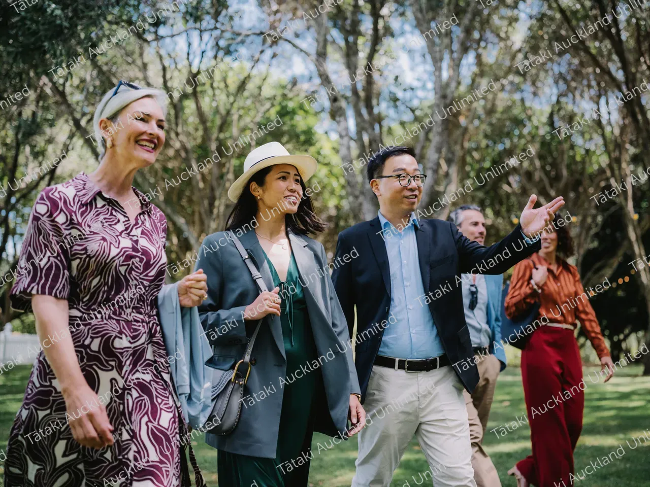 Group of business professionals walk the lawns of Waiheke vineyard 2