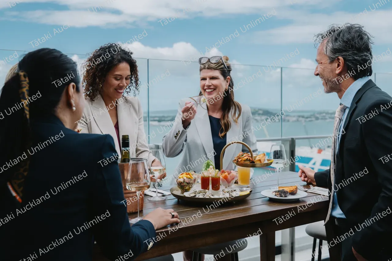 Five business professionals share a rooftop terrace meal 2