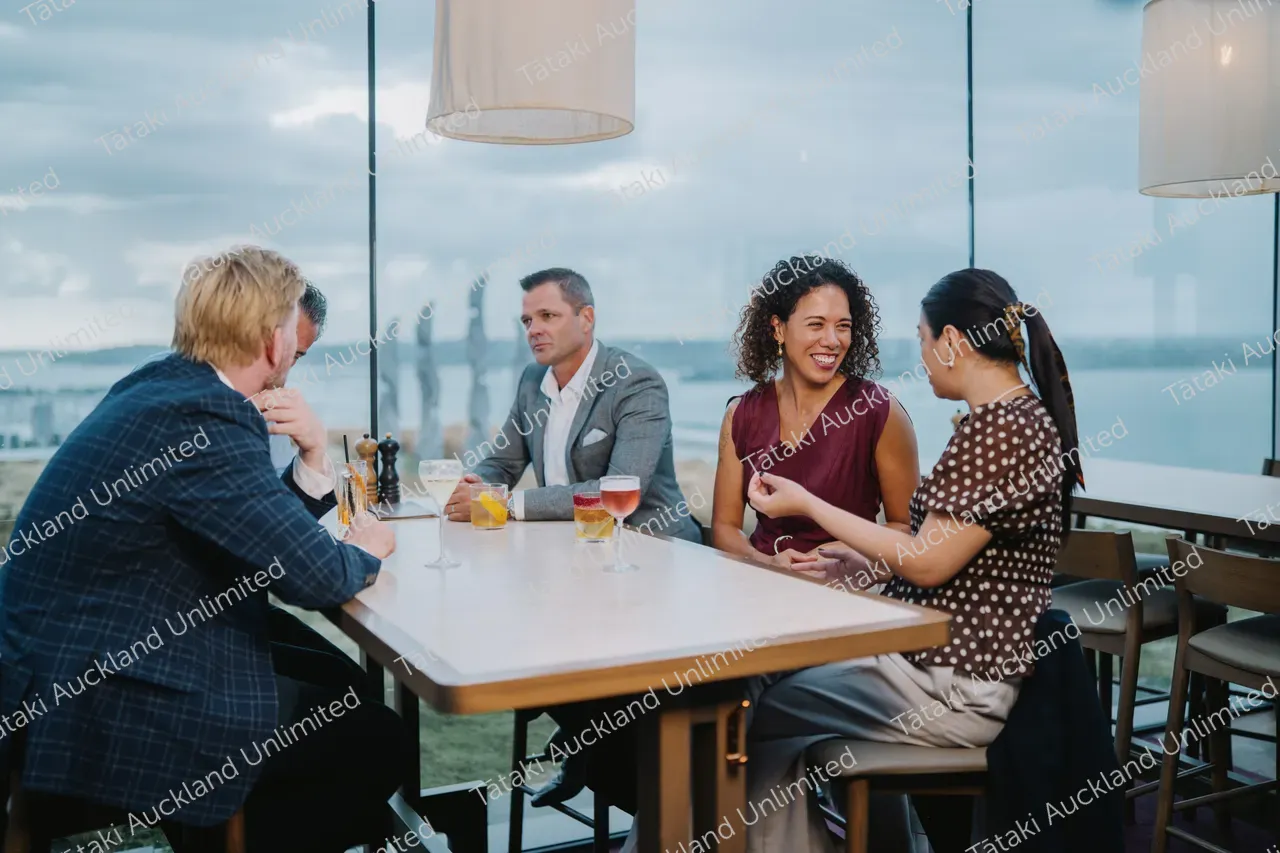 Five business professionals share a rooftop terrace meal 4