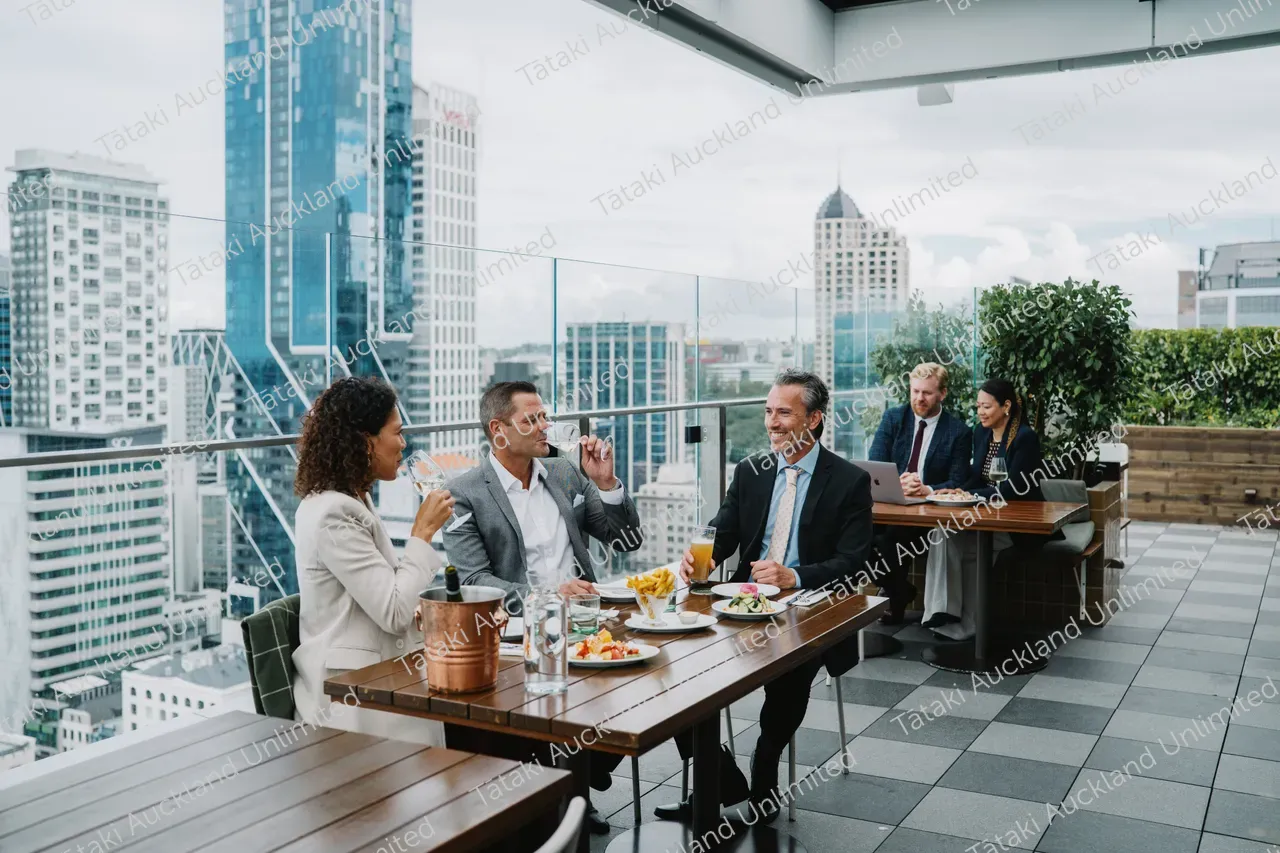 Business professionals dine on a rooftop terrace with city skyline views 8