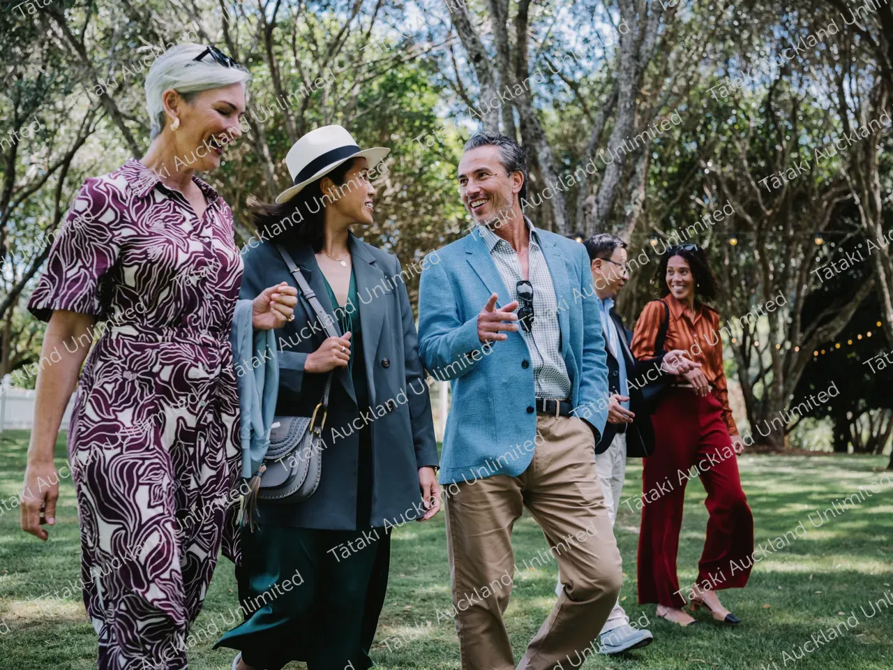 Group of business professionals walk the lawns of Waiheke vineyard 3