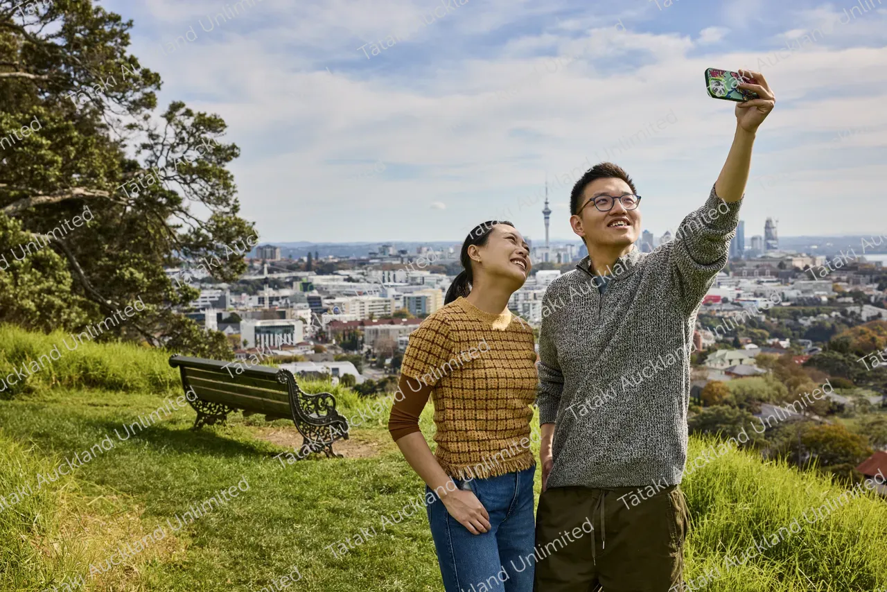 Couple admires the city view from Ōhinerau Mt Hobson 2