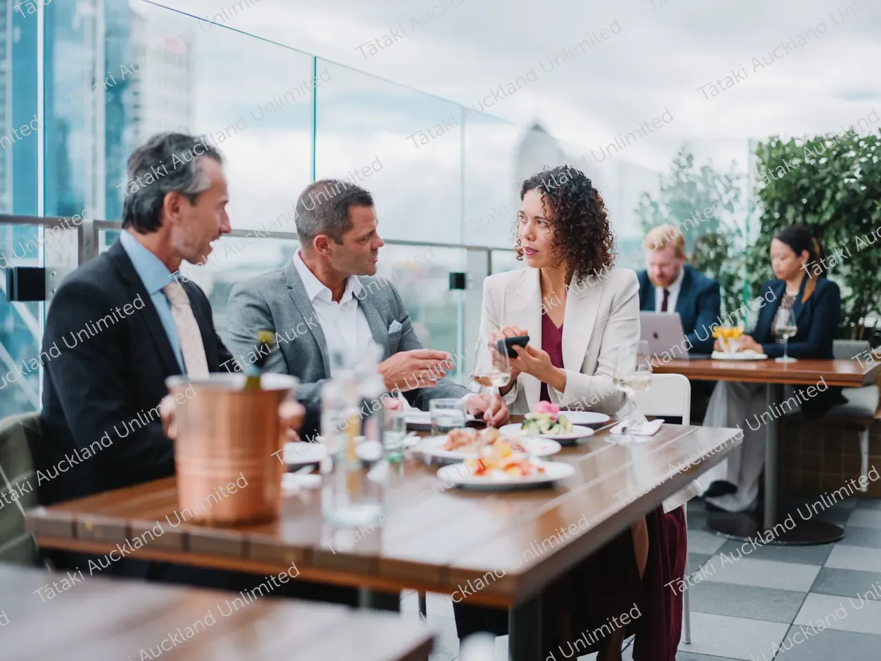 Business professionals dine on a rooftop terrace with city skyline views 6