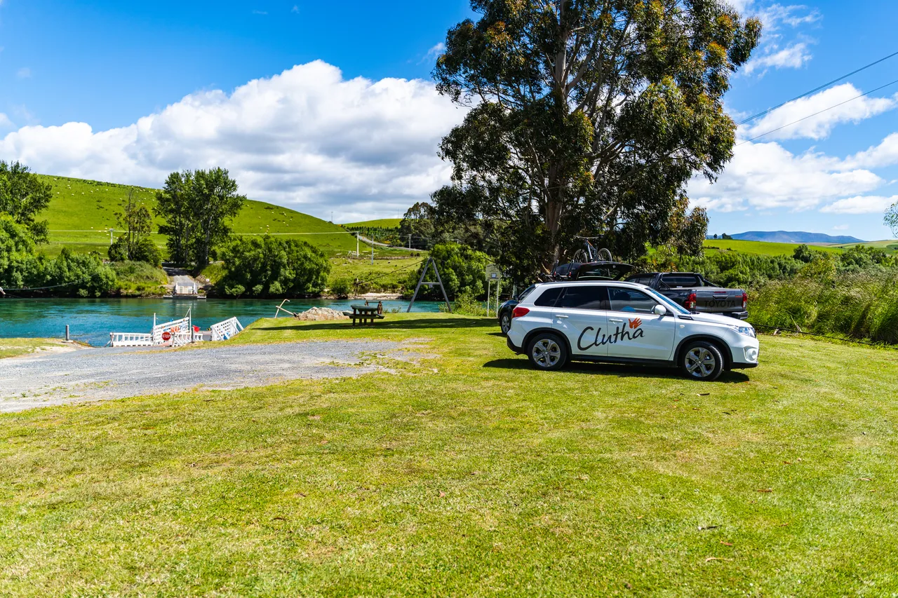 Cars parked on lawn beside river