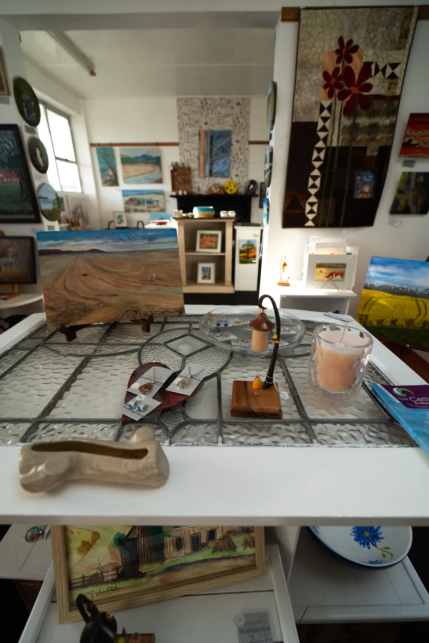 Earrings, artwork and candle sitting on table