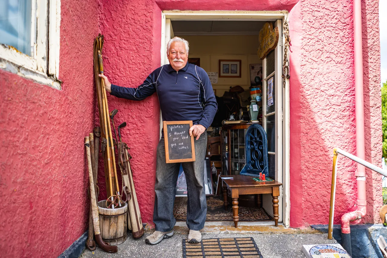 John in doorway of red building