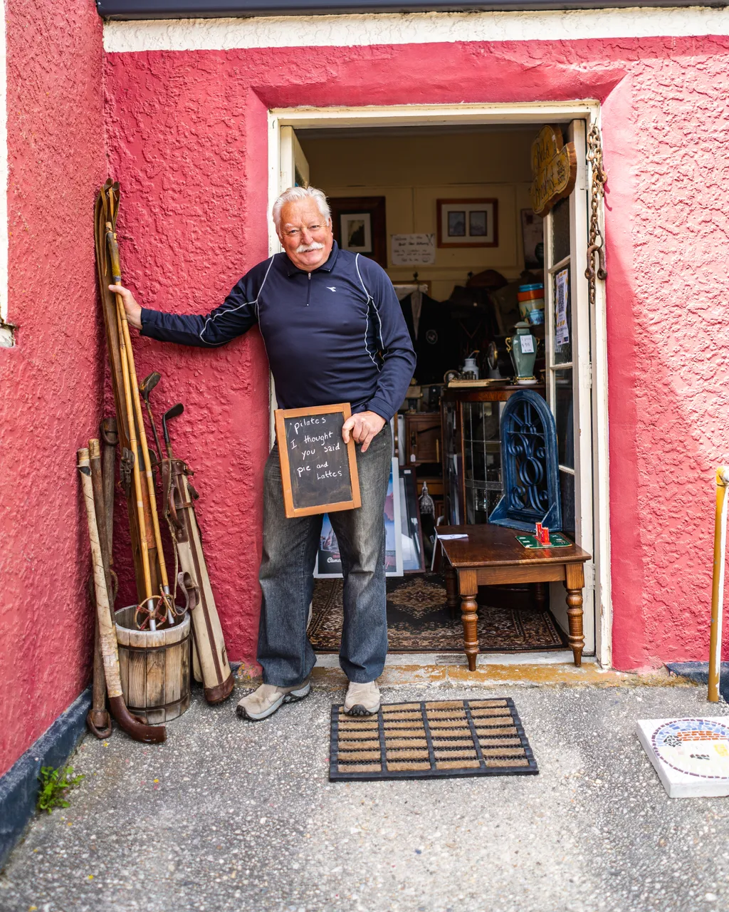 John in doorway of red building