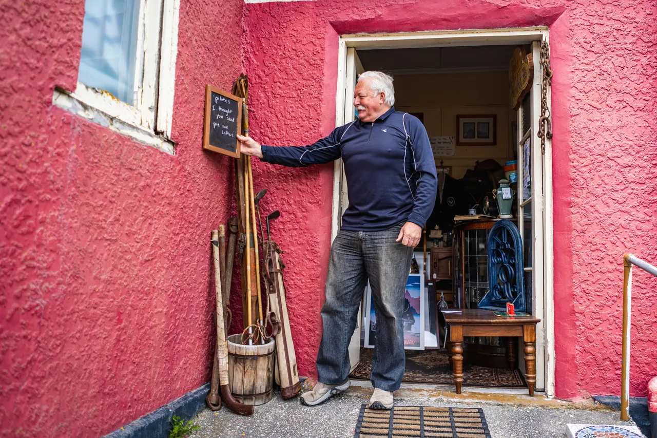 John in doorway of red building