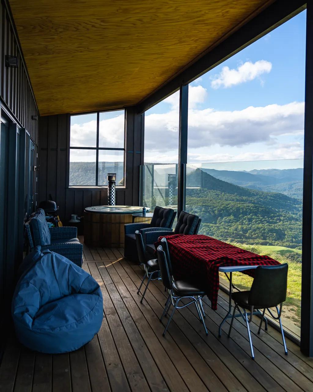 A table and beanbags on a deck with a nice view
