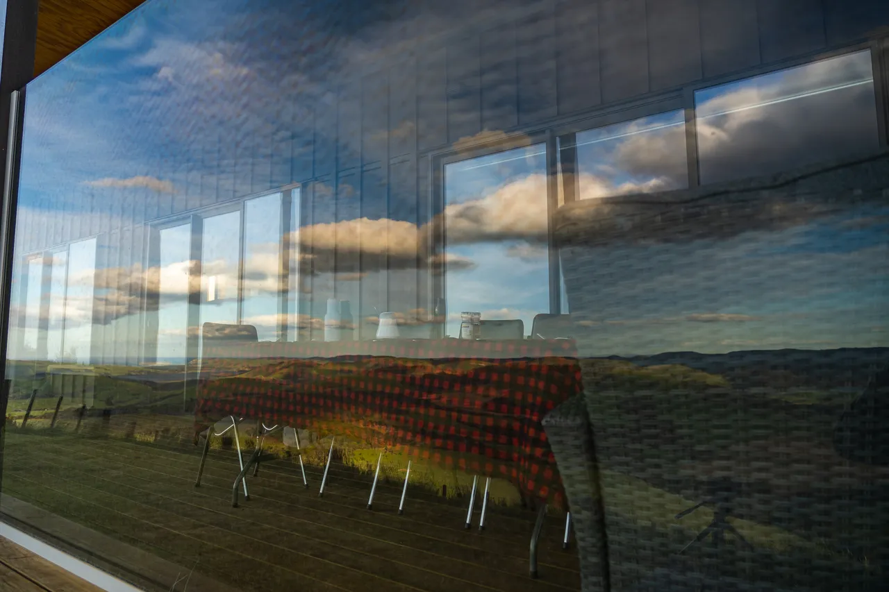A table on a deck with reflection of clouds