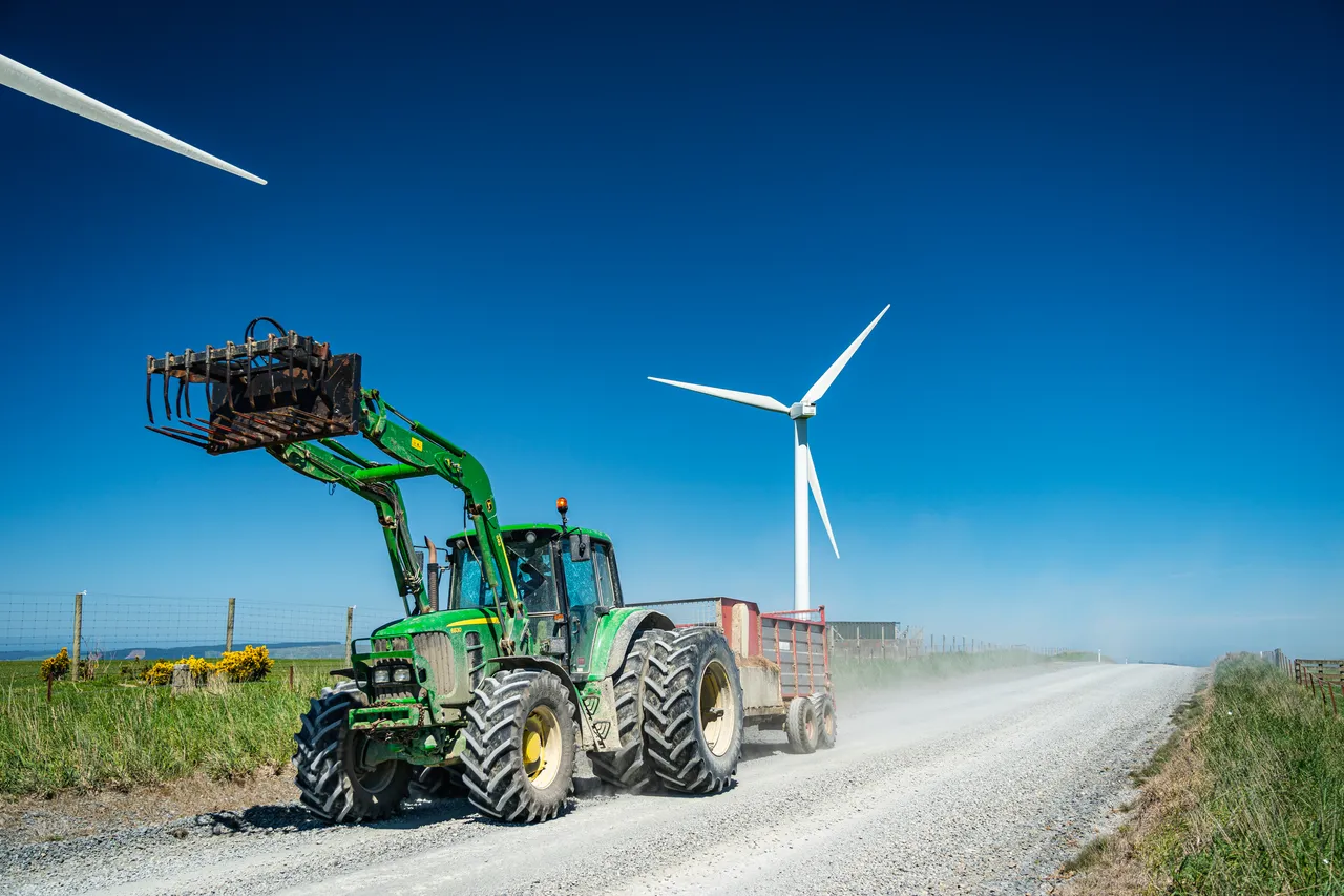 Wind turbines and gravel road with tractor