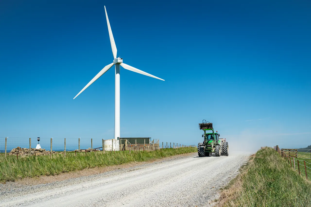 Wind turbines and gravel road with tractor