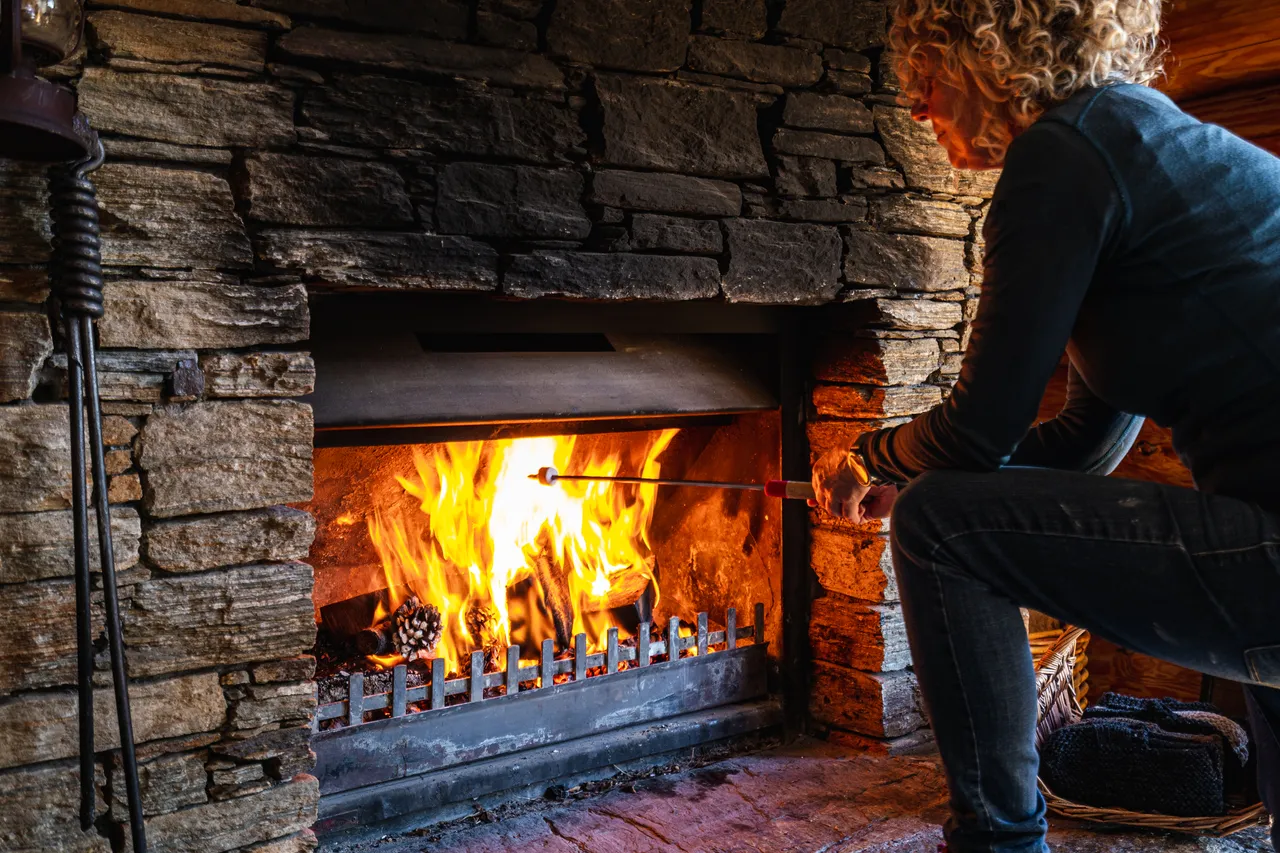 Person roasting marshmallows on the fireplace