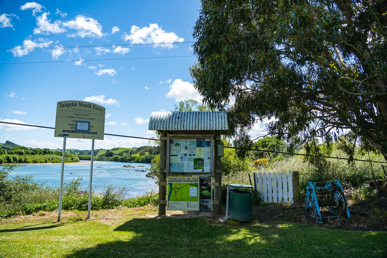 Sign on lawn beside river