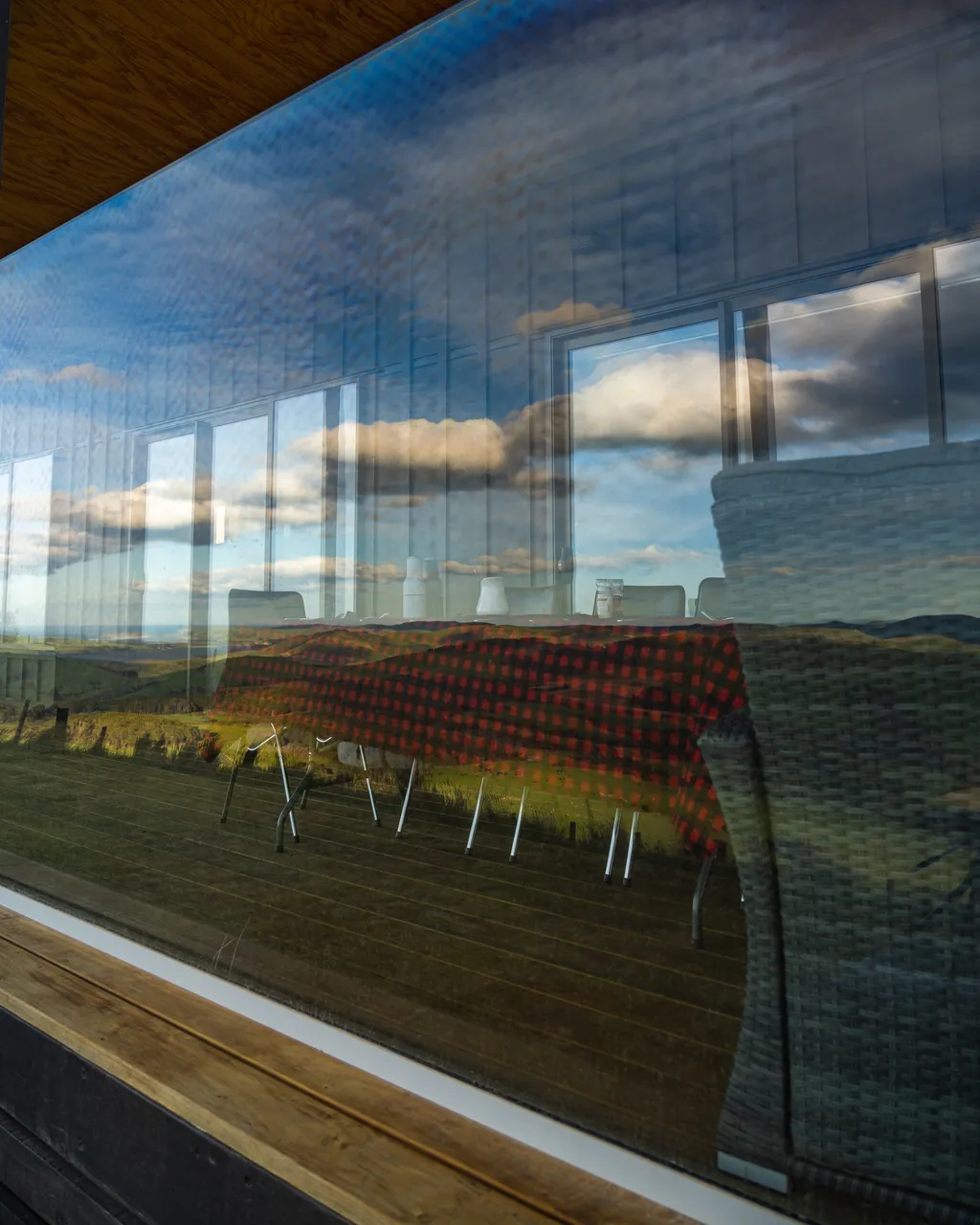 A table on a deck with reflection of clouds