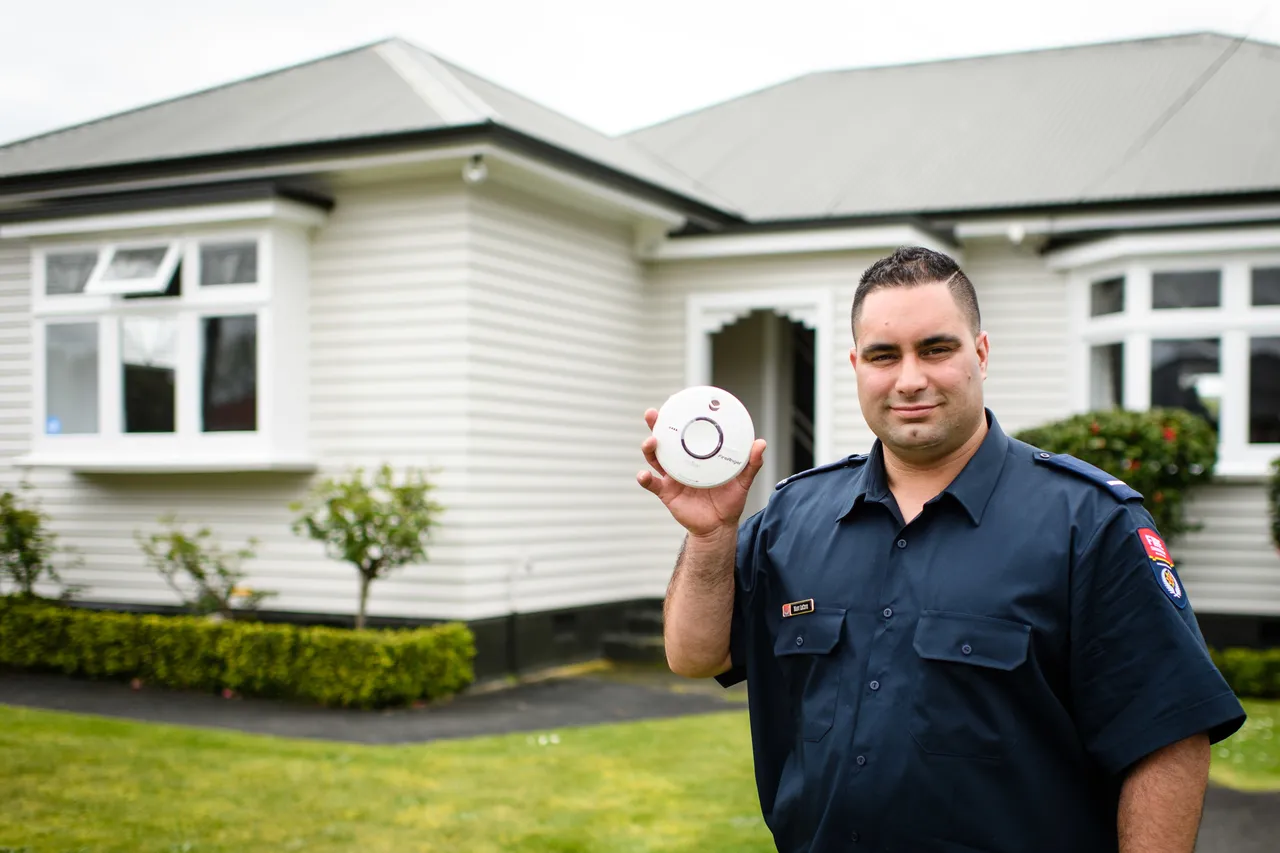 Man holding smoke alarm