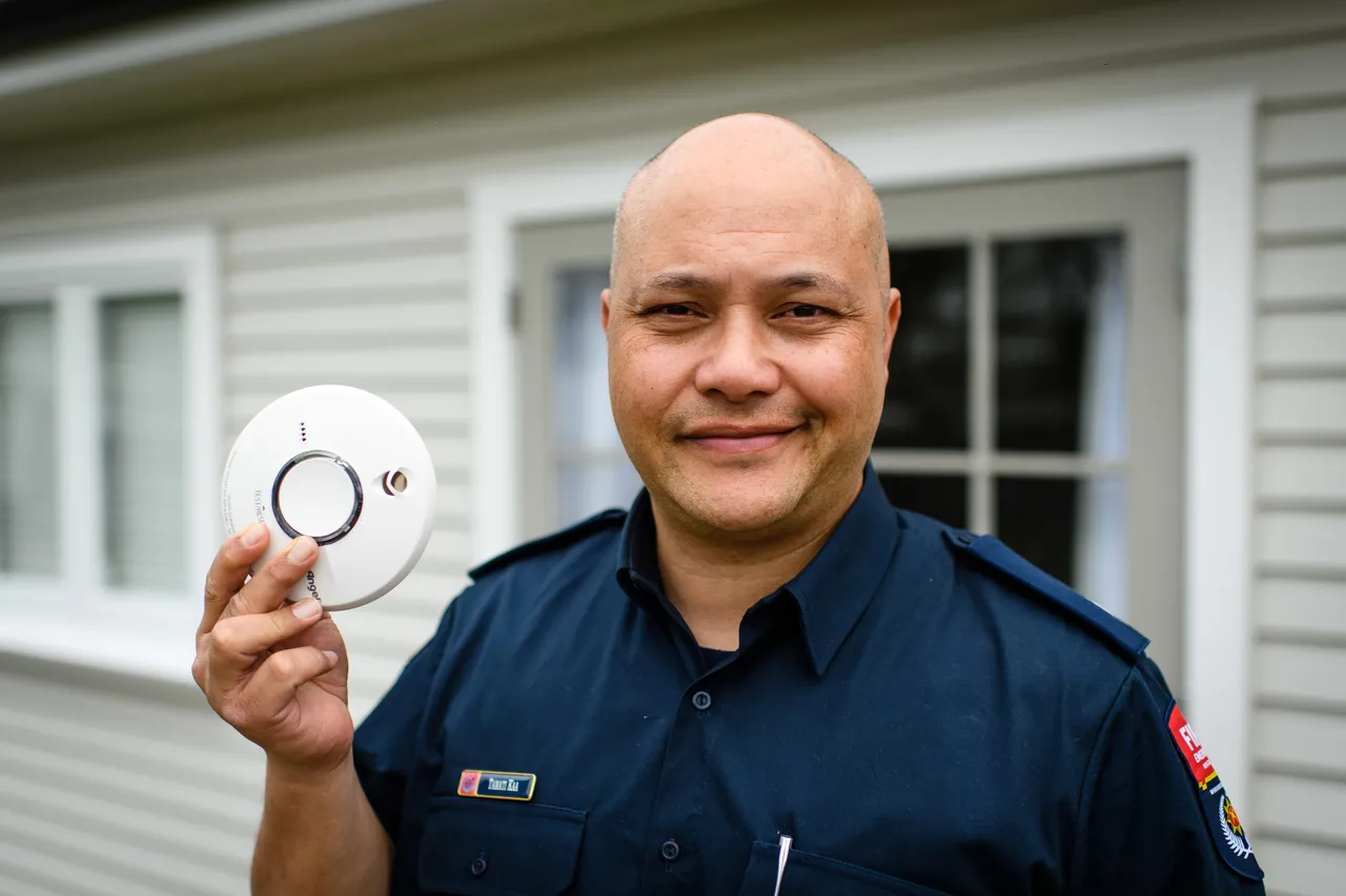 Man holding smoke alarm