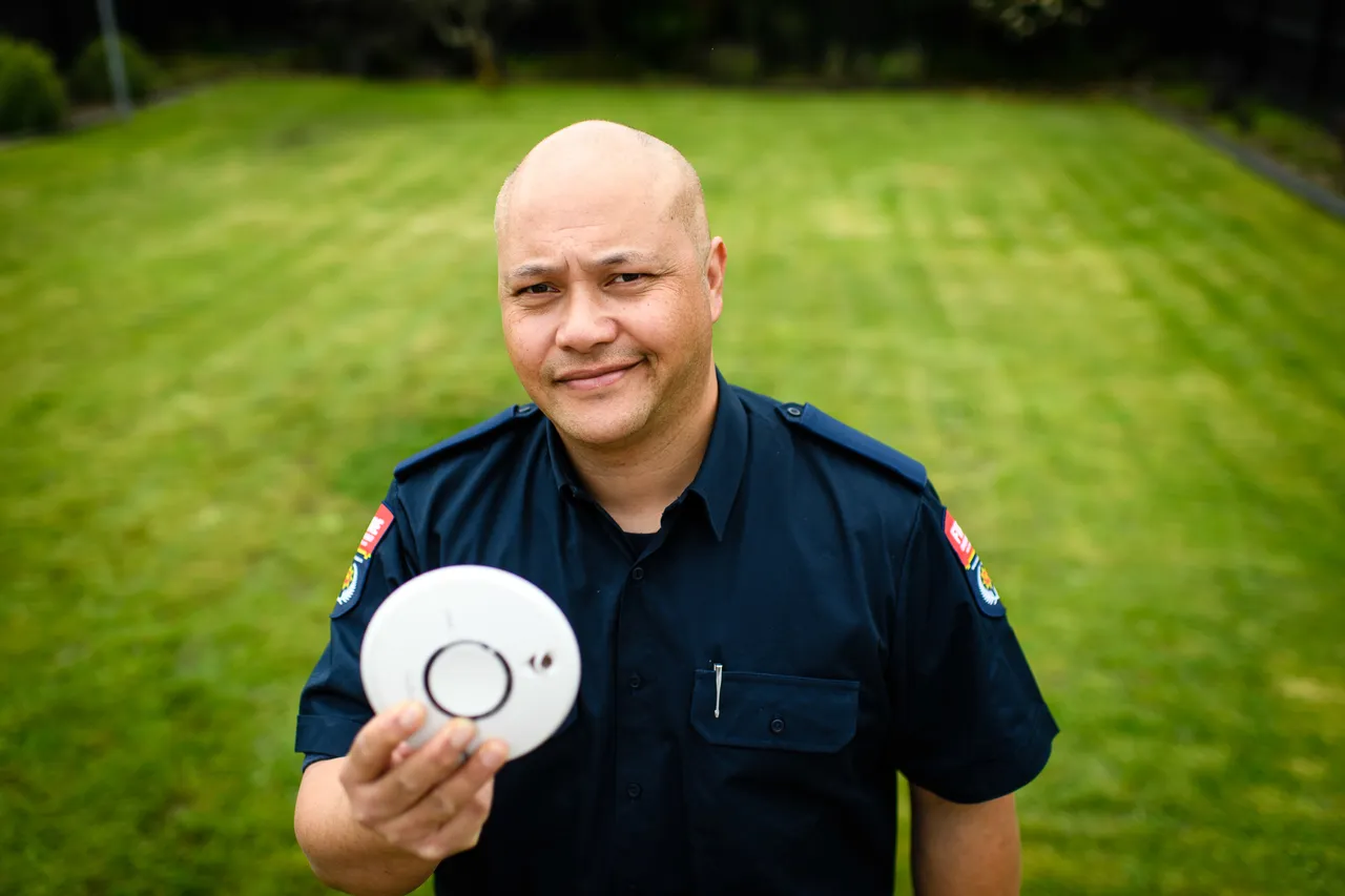Man holding smoke alarm