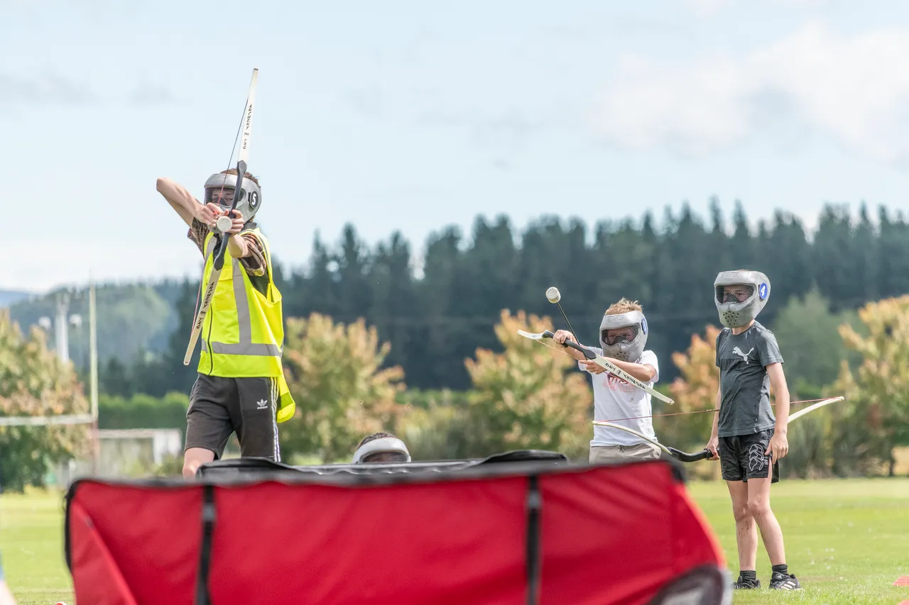child shooting play arrows in a park