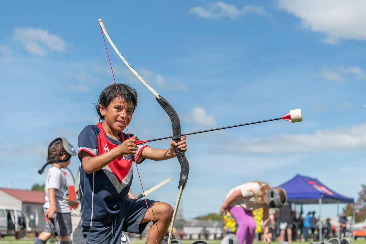 child shooting play arrows in a park