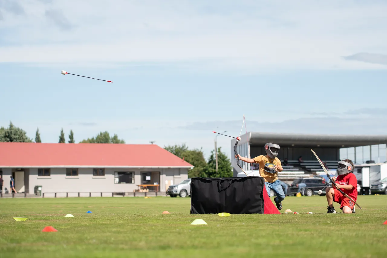 child shooting play arrows in a park