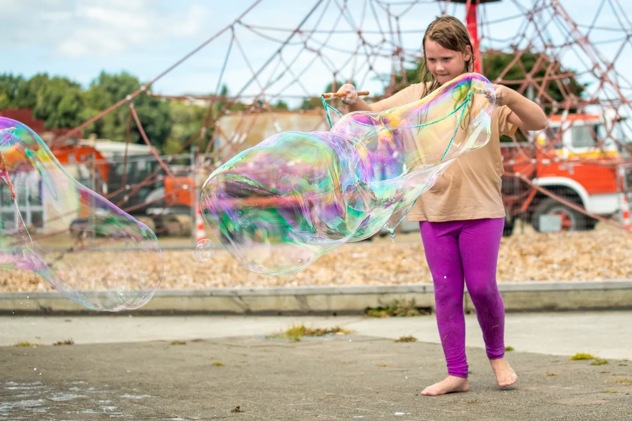 child playing with giant bubbles