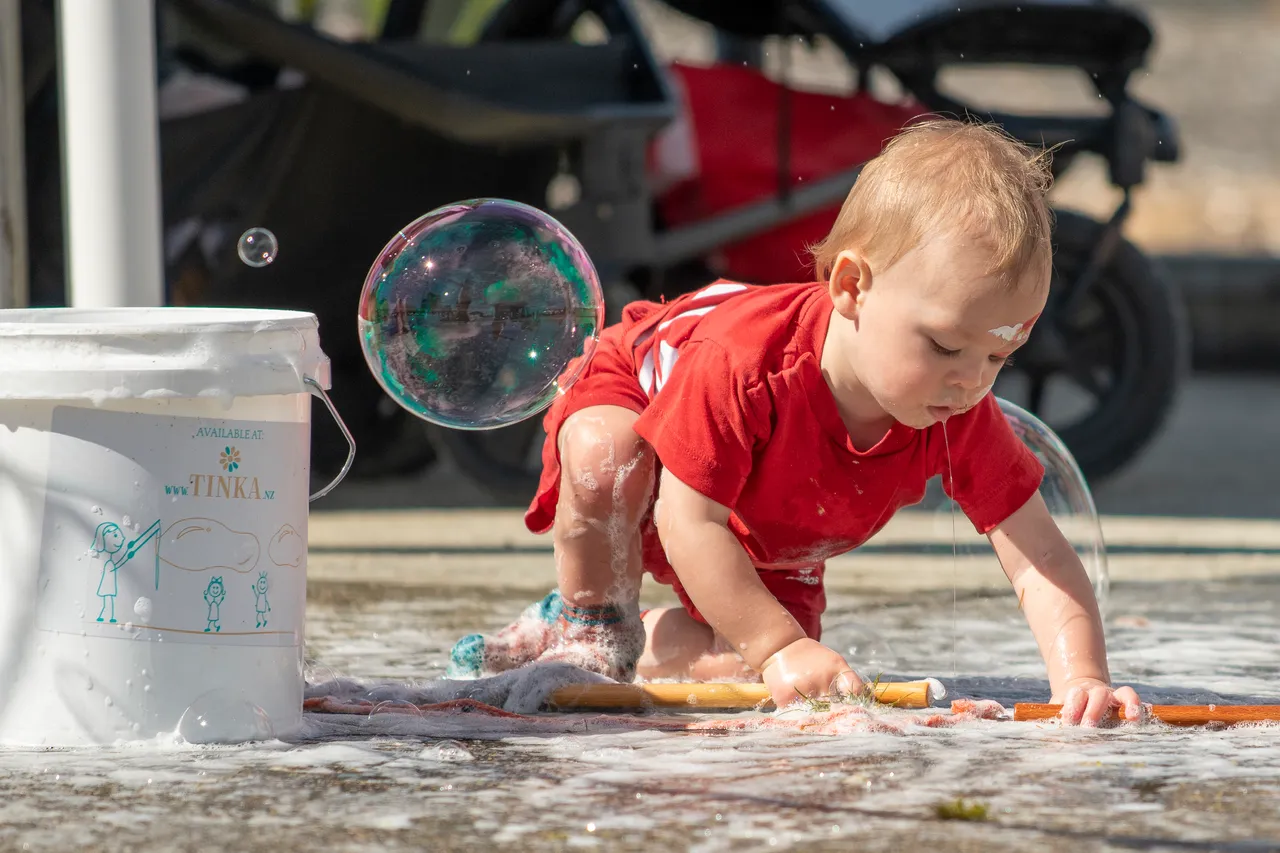 child playing with giant bubbles