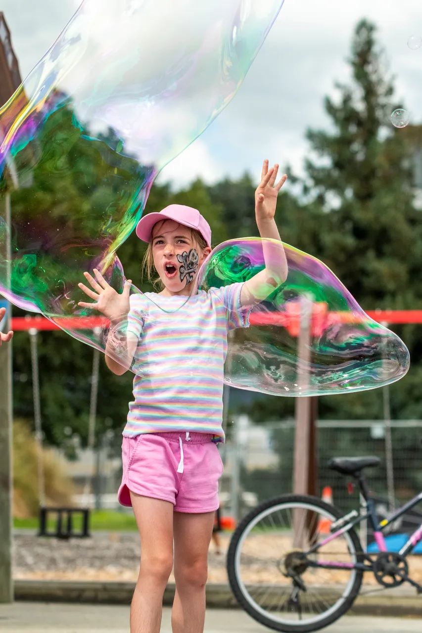 child playing with giant bubbles